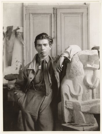 Zadkine dans son atelier de la rue Rousselet, accoudé à « Formes féminines » vers 1920